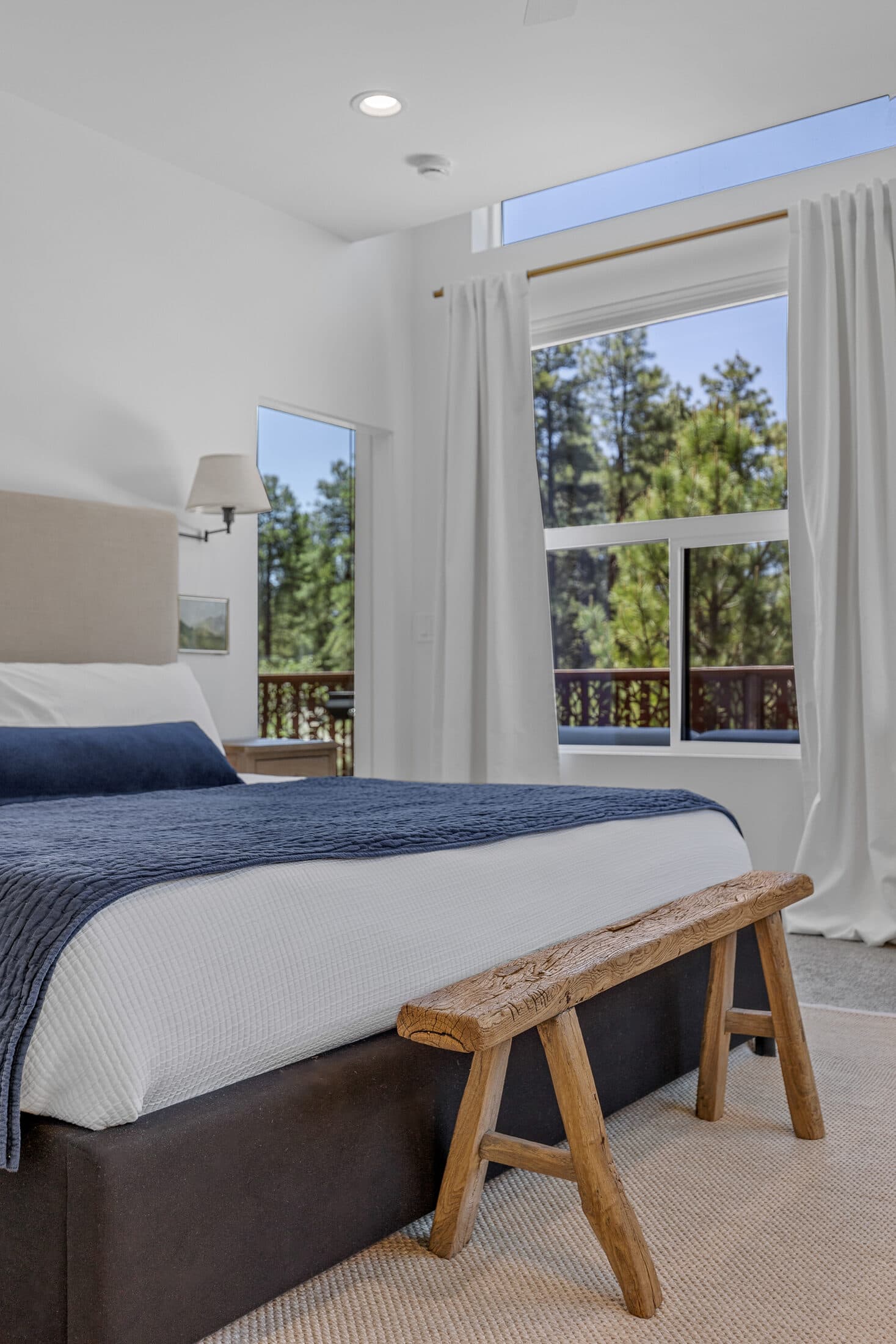 Queen bedroom with a bench and treetop views