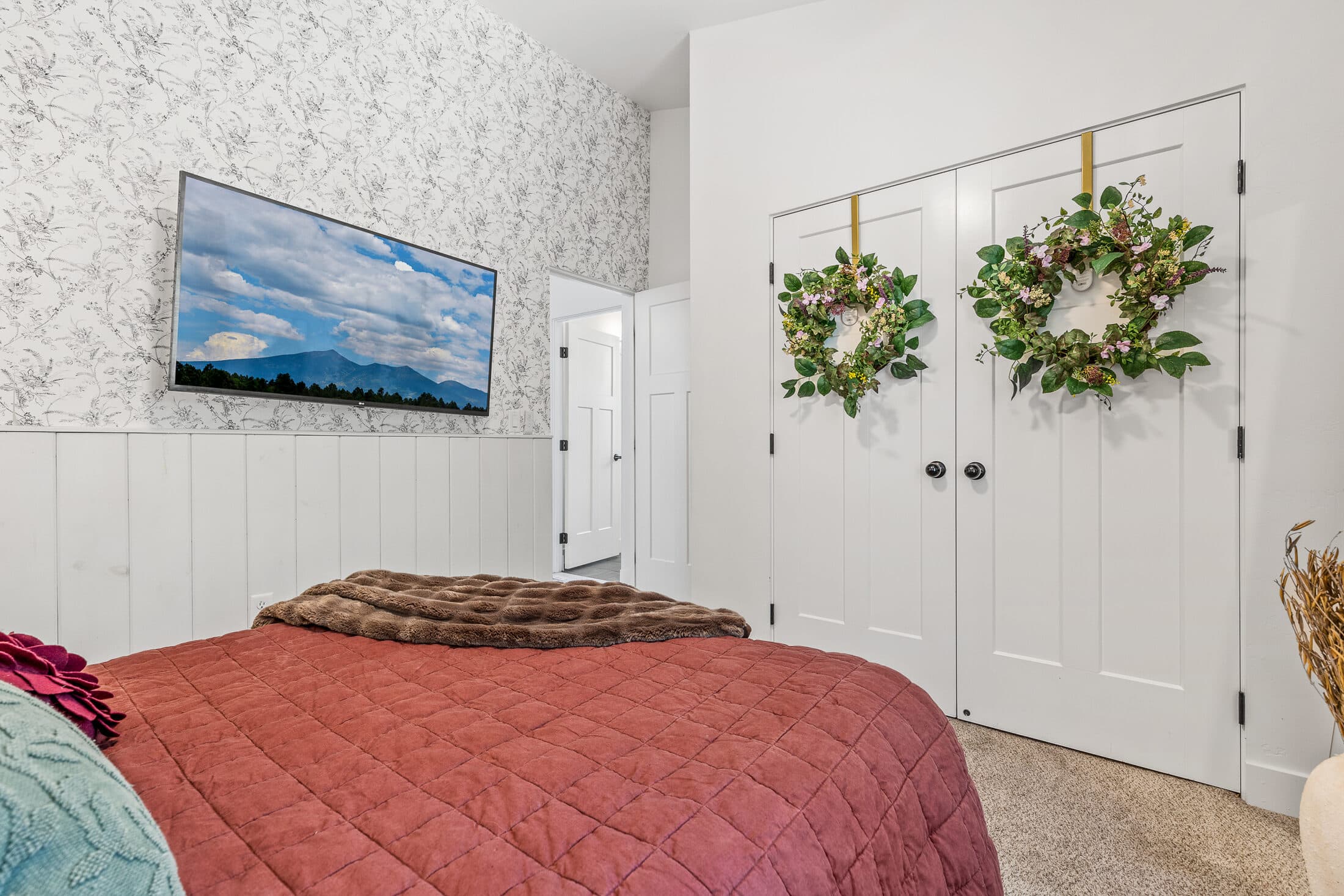 Warm-toned bedroom with a wall-mounted TV