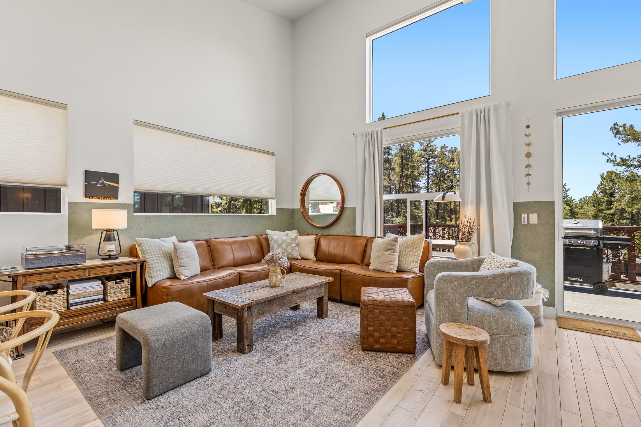 Leather sectional and lounge chairs beside the tall great-room windows