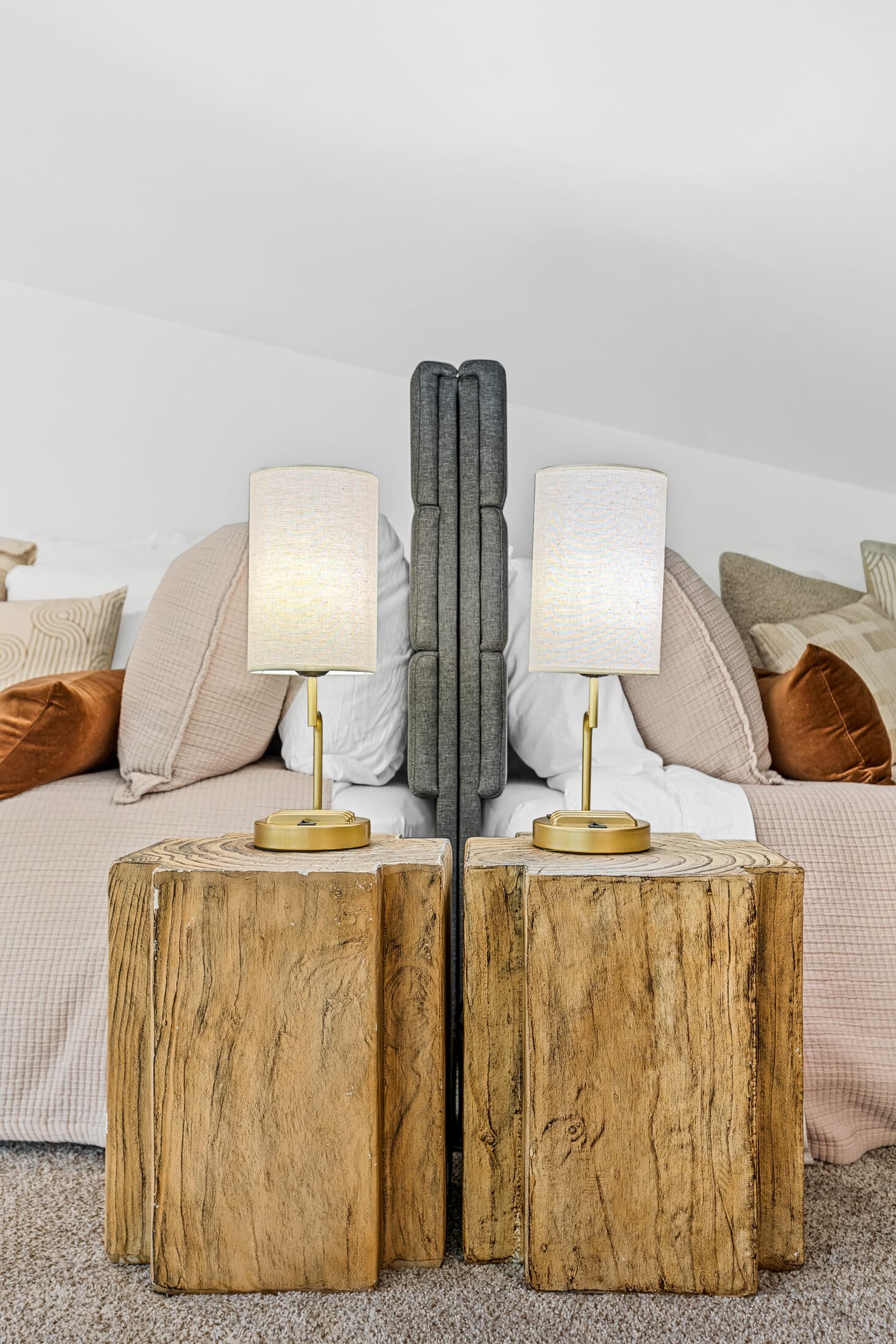 Loft bed dressed in soft linens with live-edge nightstands