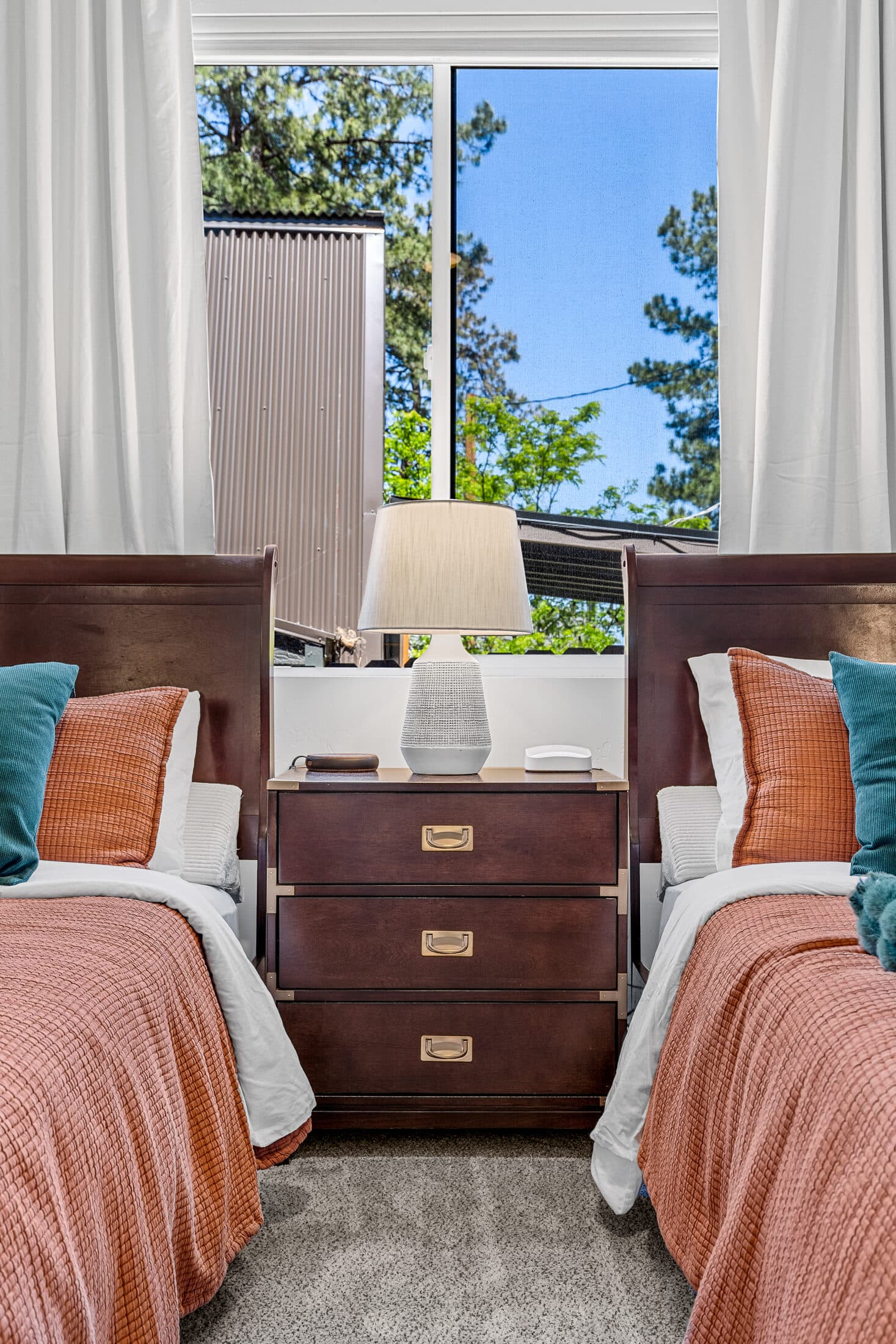 Bedroom with two beds dressed in rust linens