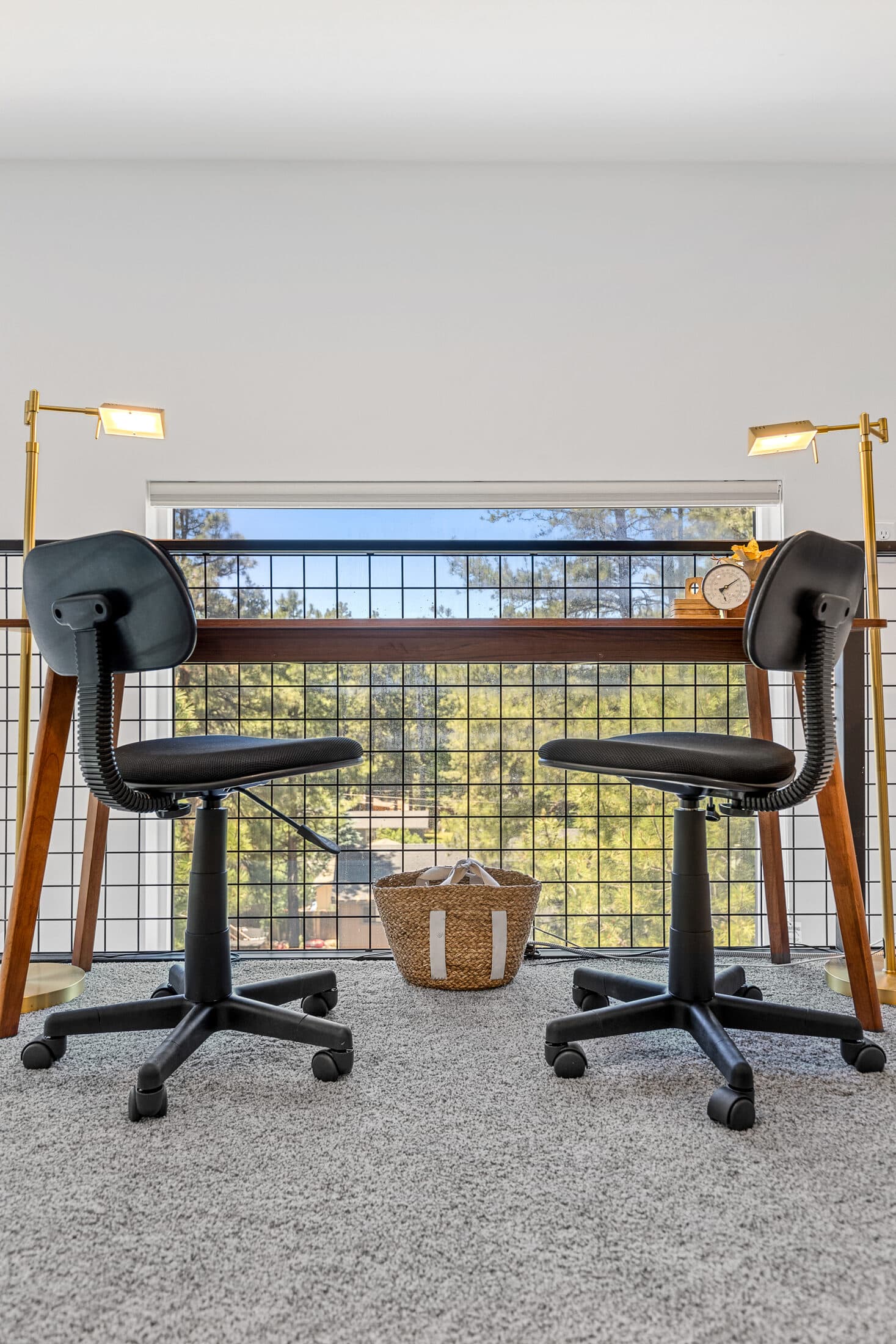 A two-desk workspace with treetop views